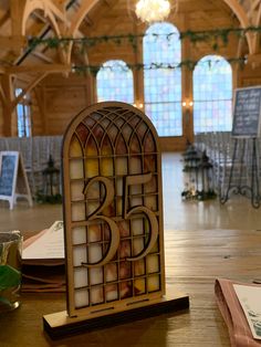 the table is set up for a wedding reception with an old stained glass window in the center