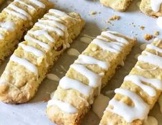 there are several cookies with icing on the baking sheet and one is cut in half