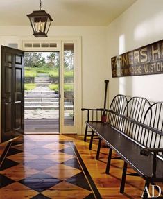 an entryway with two benches and a lantern hanging from the ceiling, along with a door leading to another room