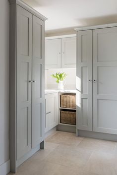 a kitchen with white cupboards and a basket in the middle of the room on the floor