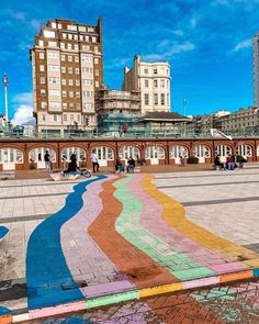 a colorful mural painted on the side of a building in front of a train station