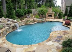 a small pool with a waterfall in the middle and a fire place next to it