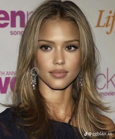 a woman with long blonde hair wearing earrings