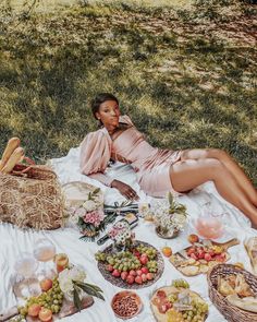 a woman laying on top of a blanket covered in food