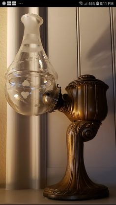 a glass vase sitting on top of a table next to a mirror