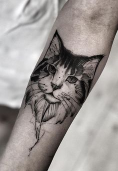 a black and white cat tattoo on the arm