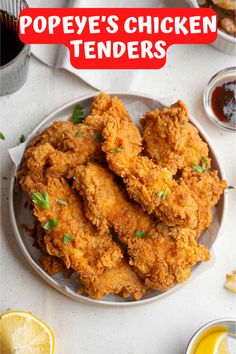 fried chicken tenders on a plate with lemon wedges