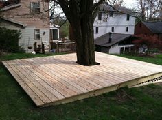 a wooden deck with a tree in the middle