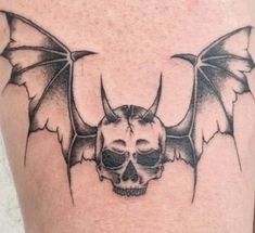 a skull and bat tattoo on the leg