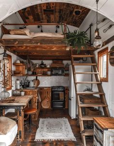 the interior of a tiny home with stairs leading up to the loft and kitchen area