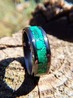 This beautiful ring features a high-tech black ceramic core with an inlay of natural green malachite stones that have been thoughtfully arranged by hand around the ring. This ring can be made in US sizes 6 to 14 including half sizes (but not 14.5). The ring shown is US size 8 and is 8mm wide with a 4mm inlay. Ceramic is extremely hard and scratch resistant. The black color will never fade or change and it is hypoallergenic. Ceramic is a great choice if you like my wood ring designs but need some Modern Green Malachite Jewelry, Green Malachite Rings With Polished Finish, Elegant Green Rings With Inlay, Elegant Green Inlay Rings, Ring With Green Stone, Wedding Band Black, Green Malachite, Malachite Stone, Black Ring