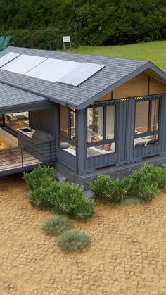 an aerial view of a small house with solar panels on it's roof and patio