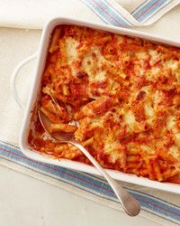 a casserole dish with cheese and tomato sauce on a blue and white towel