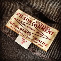 a label on the back of a jacket that says filson garment