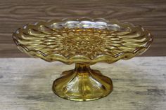 a yellow glass dish sitting on top of a wooden table