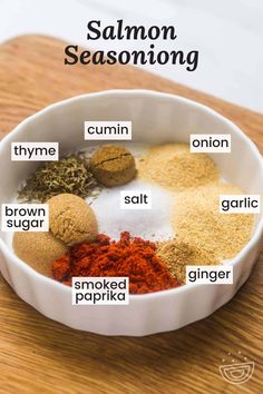 a bowl filled with spices on top of a wooden cutting board and labeled in the words salmon seasoning