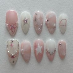 the nails are decorated with pink and white designs, including hearts, stars, and pearls