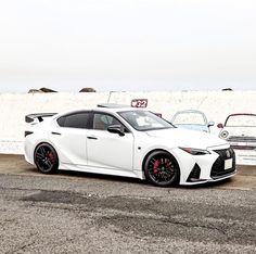 a white car parked in front of a wall