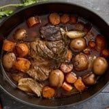 a pot filled with meat, potatoes and carrots