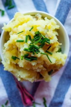 a bowl filled with mashed potatoes on top of a blue and white striped towel