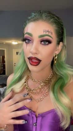 a woman with green hair and makeup is posing for the camera