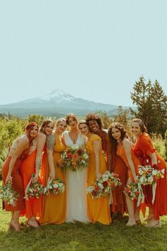 a group of women standing next to each other on top of a lush green field