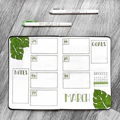 a planner with green leaves on it next to two pens and a marker that says march