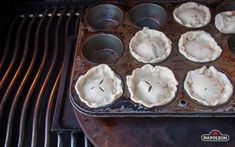 there are many pies in the muffin tins on the stove top, ready to go into the oven