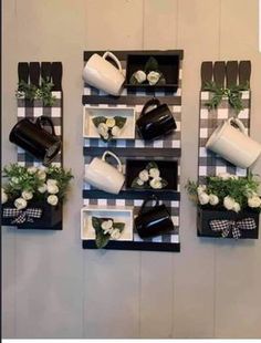 three black and white wall hangings with flowers, watering cans and teapots on them