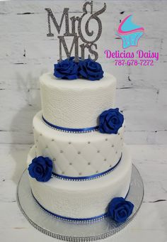 a three tiered cake with blue roses on top and the words miss and mrs above it