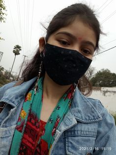 a woman wearing a black face mask on top of her head and looking at the camera