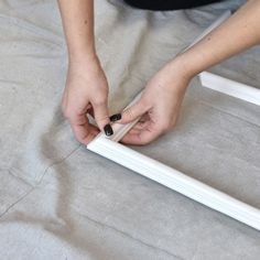 a woman is working on some white frames with her hands and nail polishing them