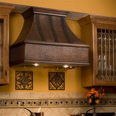 a stove top oven sitting inside of a kitchen next to wooden cabinets and cupboards