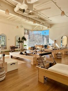 the inside of a large gym with wooden floors and mirrors on the wall above it