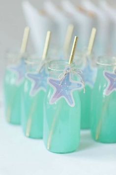 there are some little jars with straws in them and starfish decorations on the top