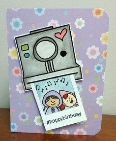 a birthday card with an image of a camera on the front, and flowers in the background