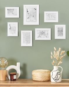 a wooden table topped with pictures and vases filled with flowers next to a potted plant