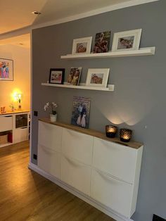 a living room filled with furniture and pictures on the wall