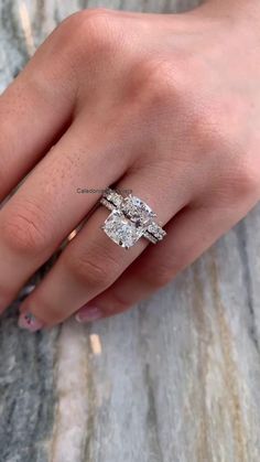 a woman's hand with two engagement rings on it