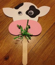 a paper cow on a stick with flowers