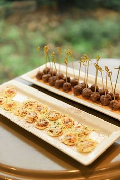 two plates with appetizers on them sitting on a table