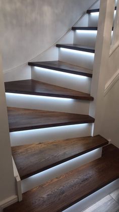 some stairs with lights on them and wood flooring in front of the stairs