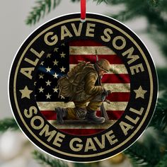 a christmas ornament with an image of a soldier kneeling in front of the american flag