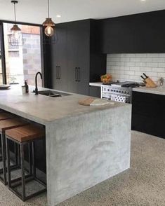 a large kitchen with an island counter and stools next to the stove top oven