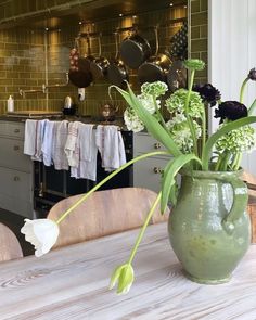 a vase filled with flowers sitting on top of a table next to a kitchen counter