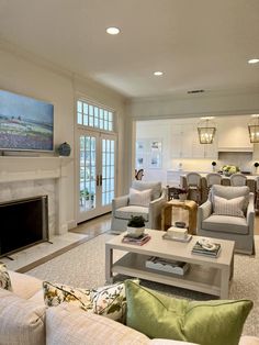 a living room filled with furniture and a flat screen tv mounted on the wall above a fireplace