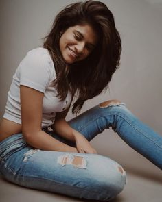 a woman sitting on the ground with her legs crossed