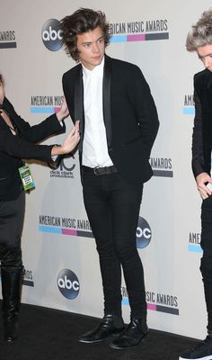 two men in black suits and white shirts on the red carpet at an american music awards