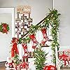 the christmas tree is decorated with red and white bows on it's staircase railing