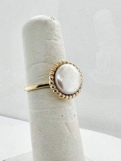 Different from your normal round pearls, this ring has a cultured coin pearl set into a 14k yellow gold buttercup setting for a nice low profile statement ring.  Currently a size 5 3/4, but can be sized at no additional cost! Classic Round Pearl Ring With Pearl Drop, Classic Pearl Ring With Pearl Drop, Yellow Gold Round Rings With Pearl Drop, Adjustable Pearl Ring For Formal Occasions, Adjustable Formal Pearl Ring, Fine Jewelry Pearl Drop Ring, 14k Gold Rings With Pearl Drop, Heirloom Pearl Round Ring, Heirloom Round Pearl Rings